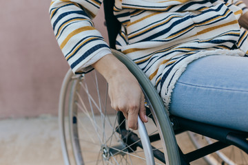 Close up of a young woman in a wheelchair while walking in a park on a sunny day. Recovery and...