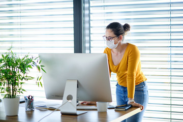 Woman working indoors at home office, Corona virus and quarantine concept.