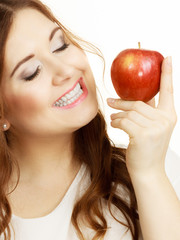 Woman holds apple fruit close to face