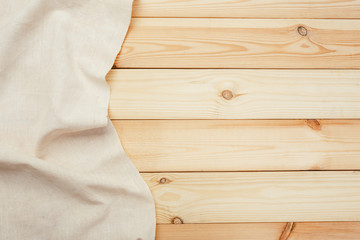 Top view on a wooden table with a linen kitchen towel or textile napkin.