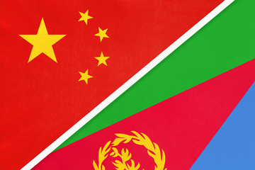 China or PRC vs State of Eritrea national flag from textile. Relationship between Asian and African countries.