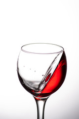 drop falling into a glass with red wine and a splash at an amazing angle