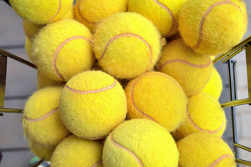 top view of yellow tennis balls lying in a basket, ready for individual training