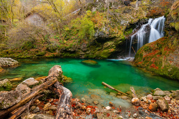 waterfall and green lake in autumn