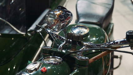 Close up of green motorcycle steering wheel and headlight. Retro style