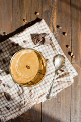 Iced Dalgona Coffee with chocolate powder in a glass cup. Trendy fluffy creamy whipped coffee.