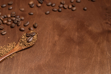 coffee beans in a spoon on a wooden background. close up. space for text