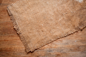 A canvas napkin lying on a wooden surface. Background for fall and natural objects.