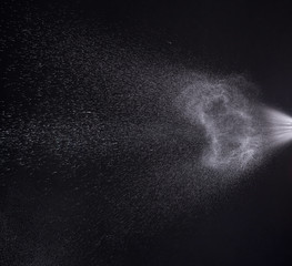a spray of liquid in a black background.