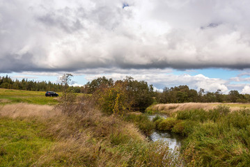 Autumn landscape with a river on a cloudy day