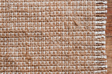 A canvas napkin lying on a wooden surface. Background for fall and natural objects.