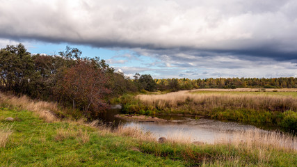 Autumn landscape with a river on a cloudy day