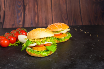 vegan Burger with lentil cutlets . vegan food with vegetable protein, herbs, tomatoes, onions on a dark wooden background. the view from the top.