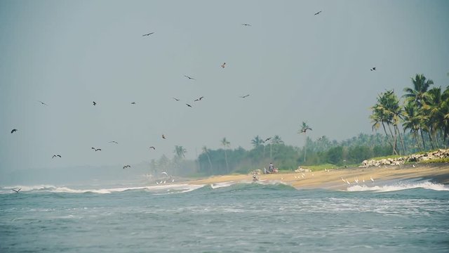 Wide View Of Kappil Beach, Varkala With Waves Crashing On The Shore Under The Bright Blue Sky Above - Wide Shot