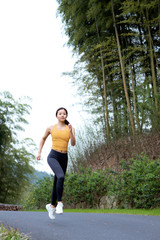 A young Asian female running outdoors