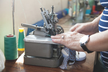 Caucasian seamstress working with sewing machine.