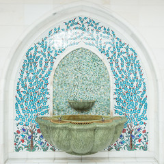 Tiled ornament drinking water fountains on forecourt of islamic mosque.