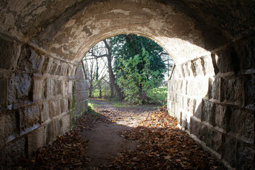 Tunnel with light at the end, there is hope at the end, stone wall tunnel. dark in the beginning