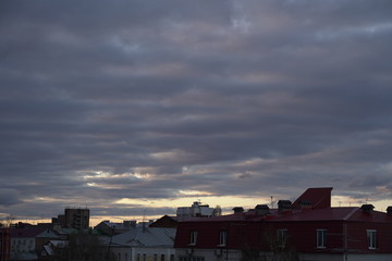 A beautiful evening blue sky at sunset with flaming bright light clouds. Warm evening.