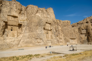 Landscape of famous landmark Naqsh-e Rustam or Rostam, the Achaemenid and Sassanid era buildings shows large tombs cut high into the mountain cliff face. Fars Province, Iran.