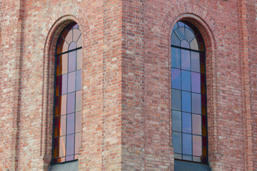 Wall of an old castle with large windows with stained glass windows.