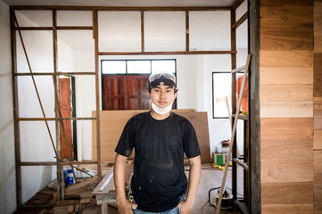 Young male carpenter portrait in workshop interior