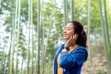 A young Asian woman walking in the bamboo forest