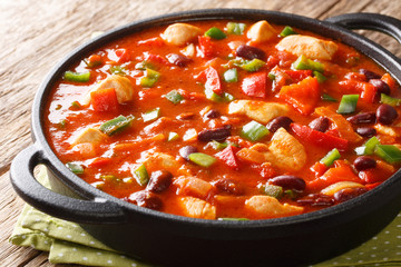 Chili chicken with red beans close-up in a pan. horizontal
