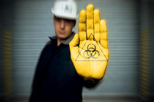 warning sign pictogram Warnung vor radioaktiven Stoffen (in german Warnzeichen, Warning of radioactive substances) Painting on workers hand