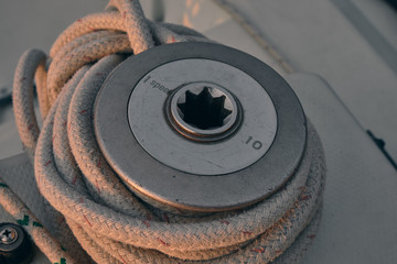 closeup white rope wrapped around sailboat winch at sunset. Yachting concept.