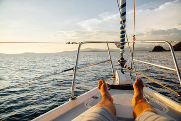 Man bare feet on a luxury deck of a yacht at sea. Relax on your little yacht.