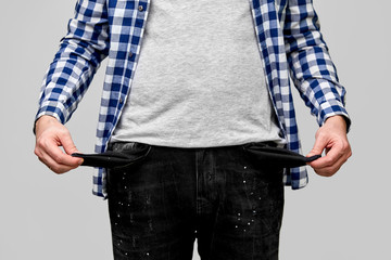 bankruptcy, financial crisis and poverty concept - close up of man showing empty pockets over gre
