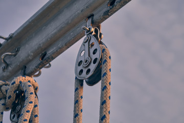 close-up sailboat equipment. Rope in snatch block at sunset. Yachting concept and sea background.
