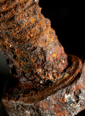 Rusted screw closeup view on black background