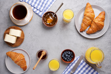 Сontinental breakfast background. Top view of gray table, croissants, orange juice, coffee, jam and butter