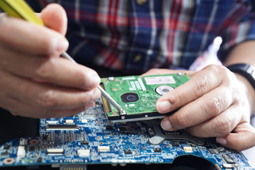 E-waste, technician repairing inside of hard disk by soldering iron. Integrated Circuit. the...