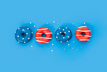 donuts with red icing and white lines and with blue icing and white stars on a blue background