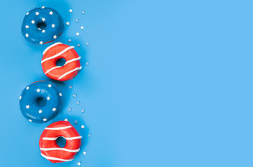 donuts with red icing and white lines and with blue icing and white stars on a blue background