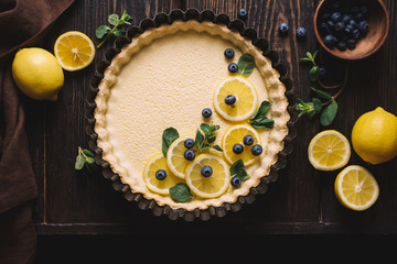 Creamy lemon tart decorated with blueberries and mint. Festive cake. Traditional french pastries