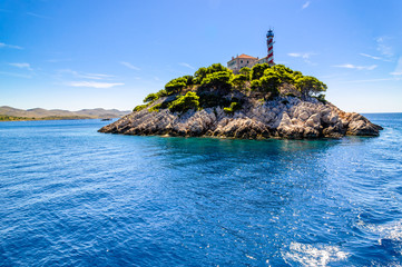 Fototapeta na wymiar Croatian rocky island with lighthouse on Vela Sestrica near Kornati, Adriatic Sea, Croatia, landscape. Vacation travel concept.