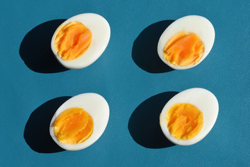 Boiled egg with shadow on blue background, abstrat and pattern concept