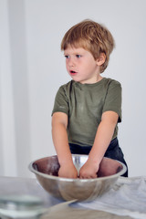 boy knead the dough on a light background