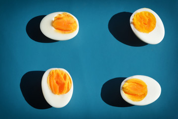 Boiled egg with shadow on blue background, abstrat and pattern concept