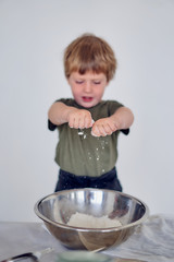 boy knead the dough on a light background