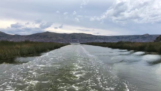 Rear view of the boat heading to the uros islands, in Puno. Trip from Puno to the Islands of Uros. Vista transera del trayecto para visitar las Islas de Uros.
