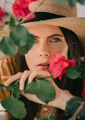 portrait of a girl in a straw hat under flowering trees in the summer in the Mediterranean 