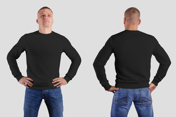 Mockup of a black empty male sweatshirt on a sporty man in blue jeans, with bent arms, front, for...
