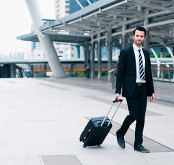 Business caucasian men dragging luggage to go to the airport. Coronavirus travel restrictions and bans globally. Concept of business travel, bans enter and leave country.