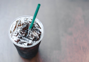 Close up glass of ice americano coffee on wood table, selective focus