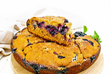 Pie with black grapes on wooden board